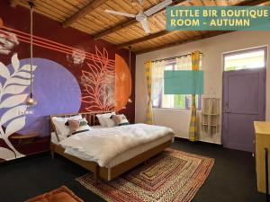a bedroom with a bed in a room with a mural at Little Bir in Bīr +176 photos