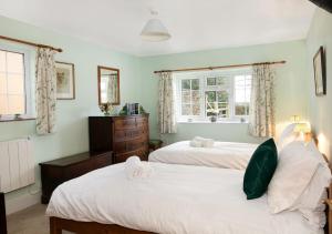 Woodcutter's Cottage - Peaceful Country Retreat! في Over Worton: غرفة نوم بها سريرين ونافذة