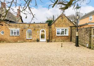 Woodcutter's Cottage - Peaceful Country Retreat! في Over Worton: منظر خارجي لبيت من الطوب مع ممر