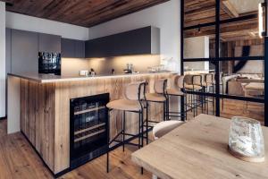 a kitchen with a fireplace and a bar with stools at Antarès SIRIUS 201 - Prestigious ski inski out apartment in Méribel