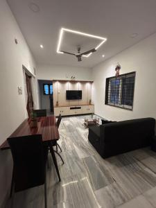 una sala de estar con un sofá y una mesa en Guhan HomeStay - 1BHK Serviced Apartments- Full Furnished & Full Kitchen, WiFi & Balcony, en Hyderabad