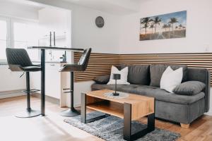 un soggiorno con un divano e un tavolo di Kleeoase - Modernes Apartment - Infrarotsauna - Terrasse - Garten - kostenlosem Parkplatz a Weinbach