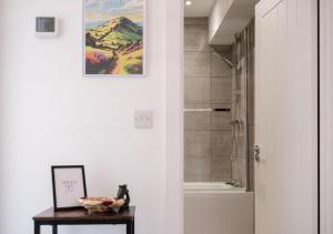 グレート・マルバーンにあるCosy 1BD in Malvern With Stunning Views!のバスルーム(シャワー付)、壁に絵が描かれたテーブルが備わります。 +36枚の写真