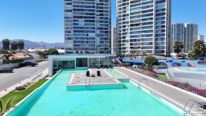 a building with a swimming pool in a city at Apartamento Playa y Casino in Coquimbo
