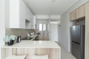 a kitchen with a white counter and a refrigerator at Casa Bella in Summerstrand