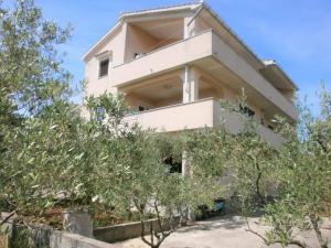 budynek z drzewami przed nim w obiekcie Apartment Lilly with outdoor Trampoline and Grill w Krku