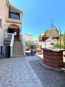 budynek z fontanną przed domem w obiekcie Apartment Lilly with outdoor Trampoline and Grill w Krku