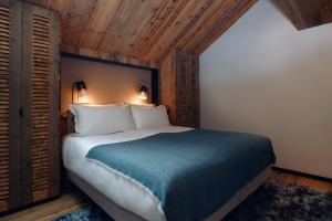 a bedroom with a large bed with a blue blanket at Antarès SIRIUS 301- Spacious ski inski out apartment in Méribel +16 photos