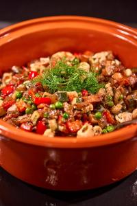 an orange bowl of food with meat and vegetables at Hotel Astoria Playa Adults Only 4* Sup in Port d'Alcudia