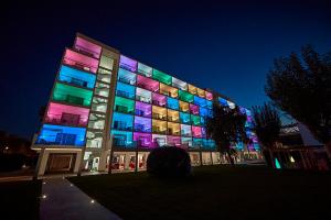 a large building with colorful lights on it at night at Hotel Astoria Playa Adults Only 4* Sup in Port d'Alcudia