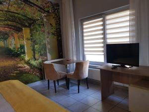 a room with a table and chairs and a television at Pensiunea Paloma 3 stele Brasov in Braşov