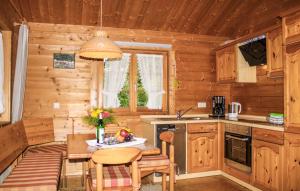 eine Küche in einem Blockhaus mit einem Tisch und Stühlen in der Unterkunft Ferienhaus Tauber 98 in Hayingen