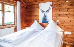 2 Betten in einem Zimmer mit einem Bild eines Hirsches an der Wand in der Unterkunft Ferienhaus Neckar 7 in Hayingen
