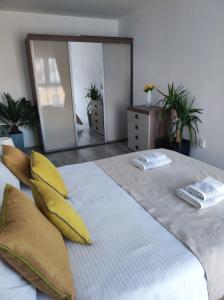 a bedroom with a large bed with yellow pillows and a mirror at grand hill panorama in Cluj-Napoca