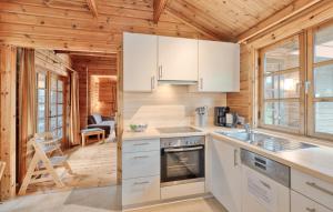a kitchen with white appliances in a wooden cabin at Ferienhaus Neckar 68 in Hayingen +8 photos