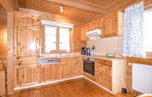 a kitchen with wooden cabinets and a sink at Ferienhaus Tauber 60 in Hayingen