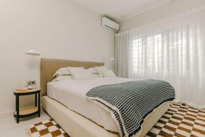a white bedroom with a large bed and a window at Tamarin Sunset Beach V in Tamarin +34 photos