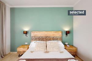 a bedroom with a large bed with blue walls at Garden Playanatural - Adults Only in El Rompido