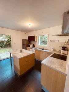a large kitchen with wooden cabinets and a counter top at LES MAISONS SERENITY Plouzané in Plouzané