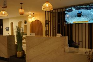 a lobby with a counter and pendant lights at فندق ريان الجنادرية للشقق المخدومة Rayyan Al Janadriyah Hotel in Riyadh