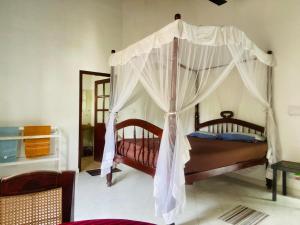 1 dormitorio con 2 camas con dosel en Berg House Unawatuna, en Galle