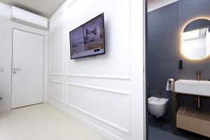 ein Bad mit einem TV an der Wand in der Unterkunft Luxury apartment-Corso Malta by Alux38 in Neapel + 29 Fotos