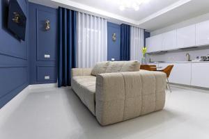 ein Wohnzimmer mit Sofa und blauen Wänden in der Unterkunft Luxury apartment-Corso Malta by Alux38 in Neapel