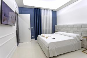 ein Schlafzimmer mit einem weißen Bett und blauen Wänden in der Unterkunft Luxury apartment-Corso Malta by Alux38 in Neapel