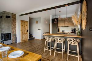 a kitchen and living room with a bar with stools at Stodołówka in Budzów