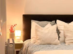 a bed with white pillows and a table with a lamp at Luxueux Appartement à Notre-Dame in Paris +8 photos