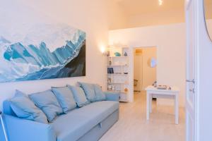 un soggiorno con divano blu e un dipinto di Rosalù - Vista mare a Polignano a Mare