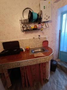 a kitchen counter with a sink and a basket on the wall at dar el fkih in Chefchaouene