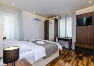 a hotel room with a bed and a flat screen tv at Villa Stone Bliss with private Pool, near Dubrovnik in Zaton +34 photos