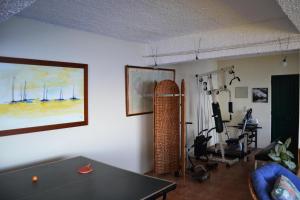 a living room with a table and a room with a gym at Casal São João Cottages in Fajã da Ovelha