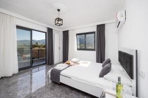a white bedroom with a bed and a large window at Villa Grand Yasar 3 in Okçular +36 photos