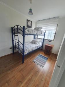 a bedroom with two bunk beds and a wooden floor at Peñuelas Club in Coquimbo