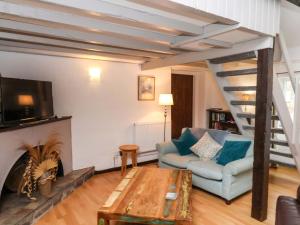a living room with a couch and a fireplace at Stable Cottage in Whitby