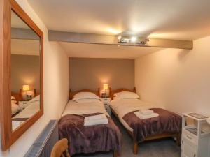 a room with two beds and a mirror at Stable Cottage in Whitby