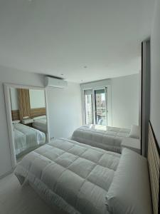 a bedroom with two beds and a large mirror at El Apartamento de Cristian 4 in Benidorm