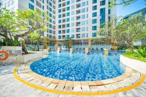 ein Schwimmbad vor einem hohen Gebäude in der Unterkunft Classica by Kozystay - Kuningan in Jakarta