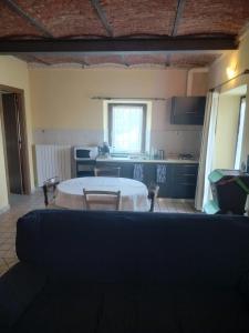 a living room with a table and a kitchen at La Rosa dei Venti in Parella +22 photos