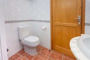 a bathroom with a toilet and a wooden door at Casa Seña Catalina, antigua casa típica canaria in La Oliva +25 photos