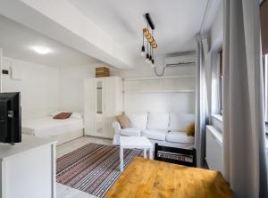 een witte woonkamer met een bank en een tafel bij Concept Studio Haven 19 in Boekarest