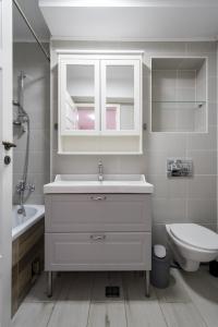 een witte badkamer met een wastafel en een toilet bij Concept Studio Haven 19 in Boekarest +26 foto's