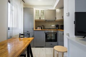 een keuken met een houten tafel en een houten aanrecht bij Concept Studio Haven 19 in Boekarest