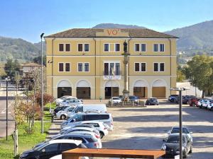 a large yellow building with cars parked in a parking lot at Locanda al Sole - Vo' in Vo Euganeo