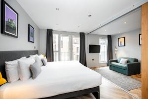 a bedroom with a large white bed and a couch at Staycity Aparthotels Edinburgh West End in Edinburgh