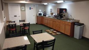 una cocina con armarios de madera, mesas y sillas en Hurricane Inn, en Waynesboro