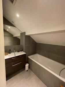 un baño con bañera y lavabo en Duplex les Myrtilles LES CARROZ centre station, en Les Carroz d'Araches