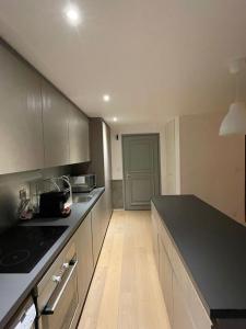 Una cocina con encimera negra en una habitación. en Duplex les Myrtilles LES CARROZ centre station, en Les Carroz d'Araches